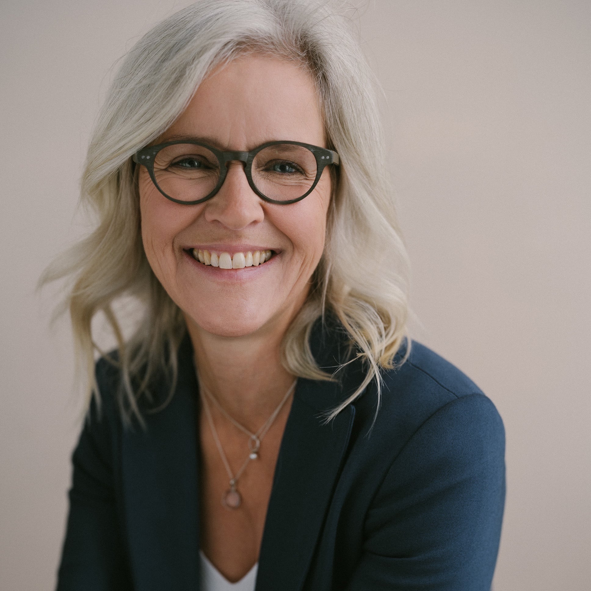 Lächelnde Frau mit Brille und grauen Haaren