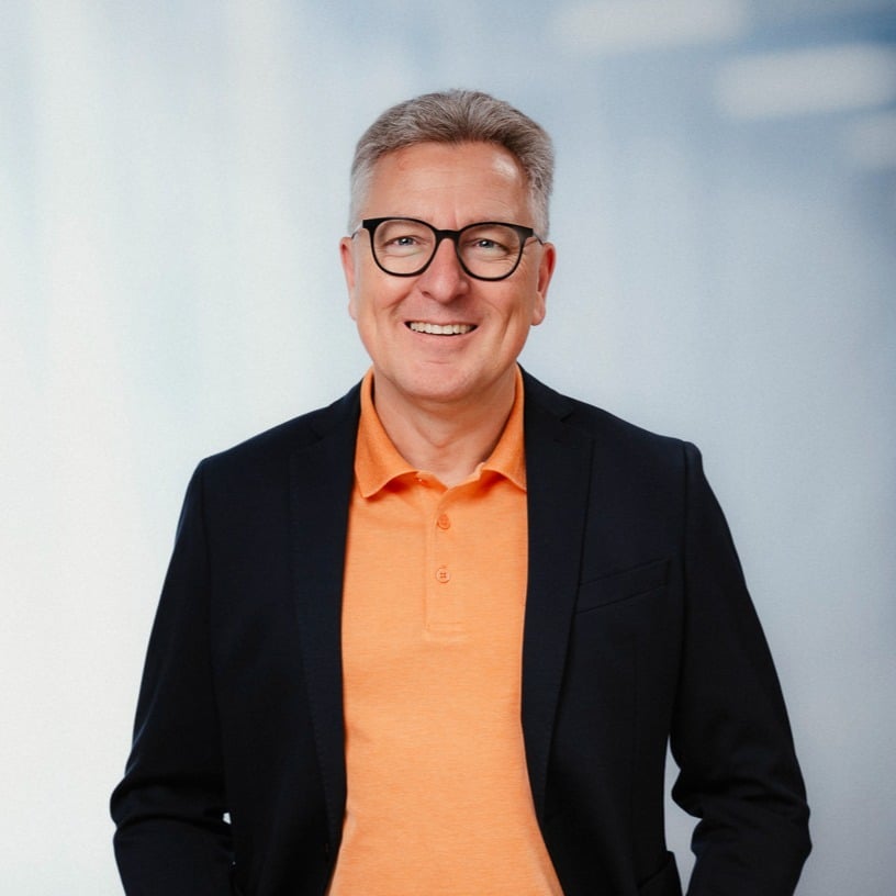 Lächelnder Mann mit Brille im orangefarbenen Hemd